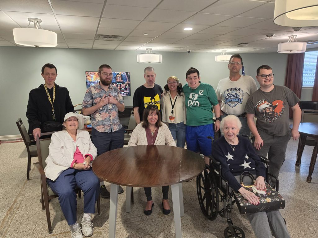 CAI participants and senior neighbors gather around a table at Bardwell Residences.