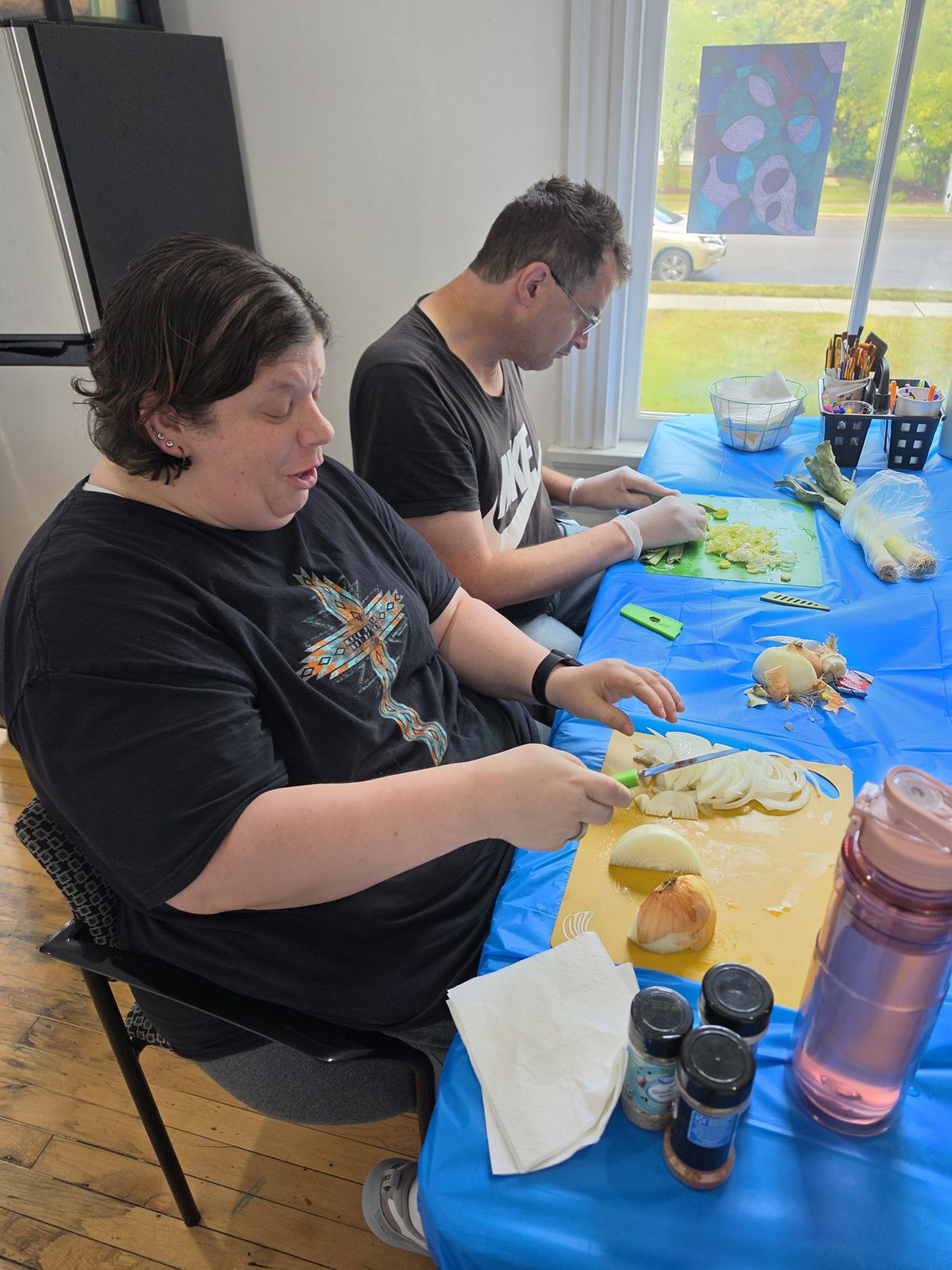 CAI participants prepare vegetables at a table for Crazy Noodle Soup.