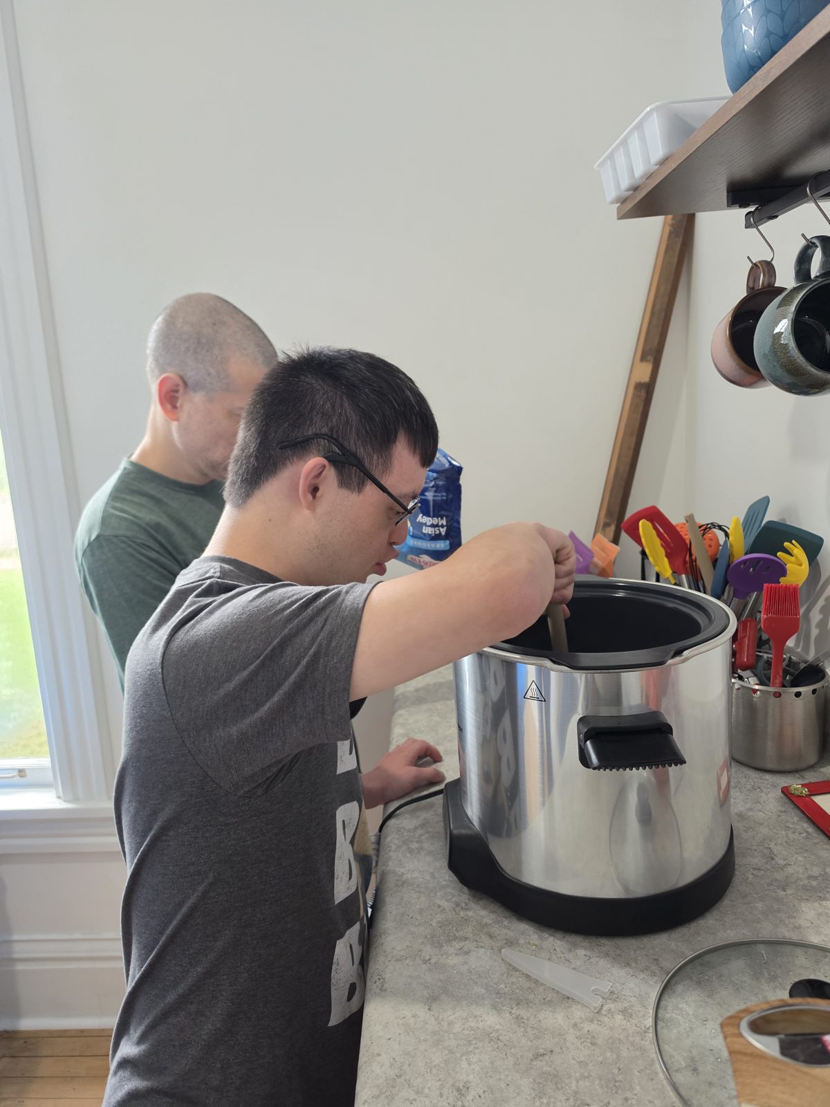 A CAI participant stirs ingredients in a cooker during the soup activity.